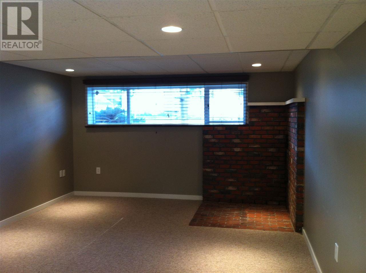 Prince George Foothills — basement rec room with brick fireplace