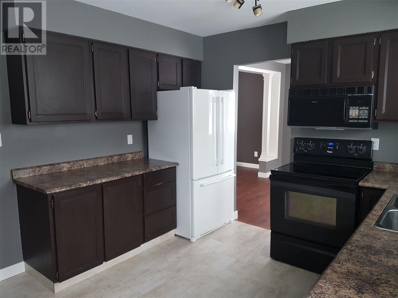 Prince George Foothills — kitchen with dark cabinets and appliances