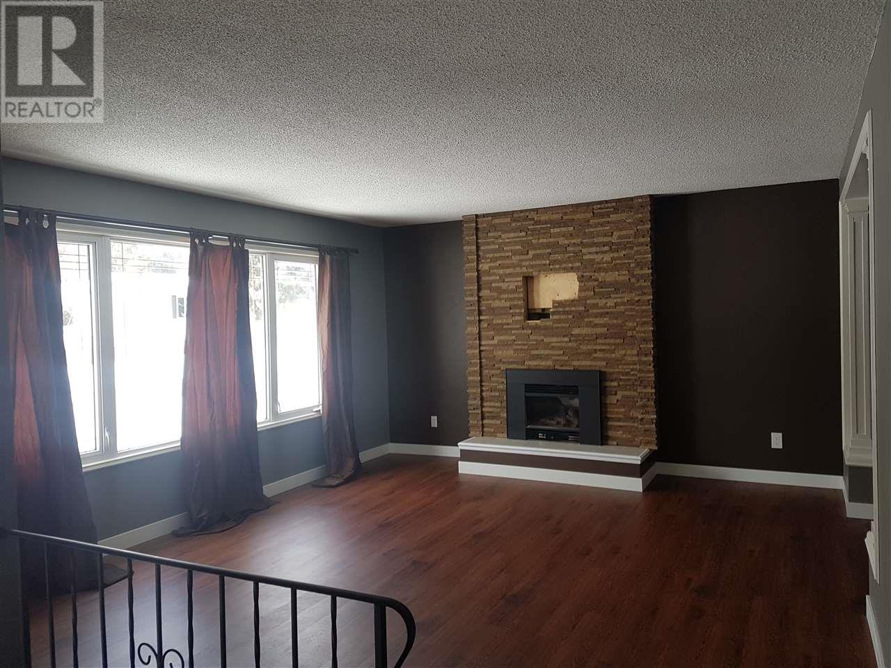 Prince George Foothills — living room with stone fireplace